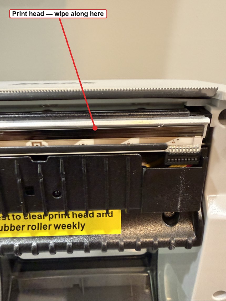 Close-up of the FreeX print head, a silver strip below the serrated tear-off bar, marked as the surface to wipe