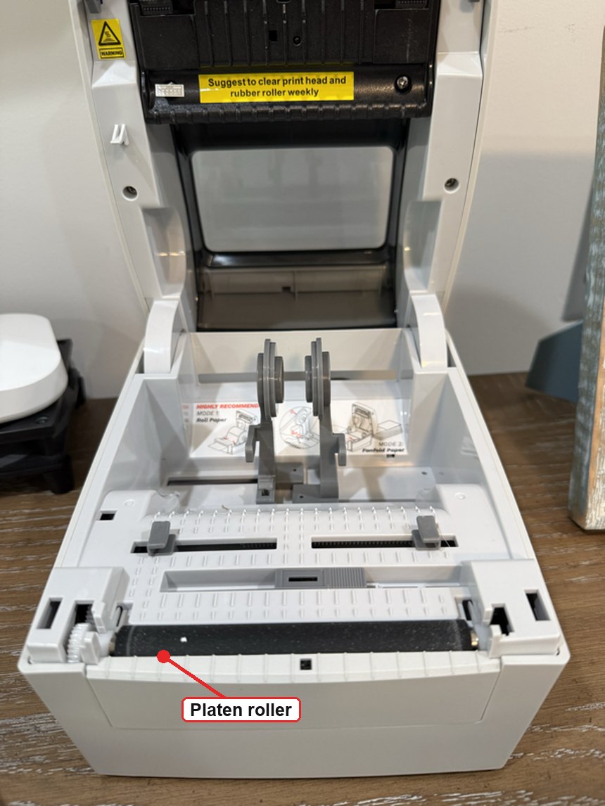 FreeX thermal printer with the cover open, showing the black rubber platen roller in the base